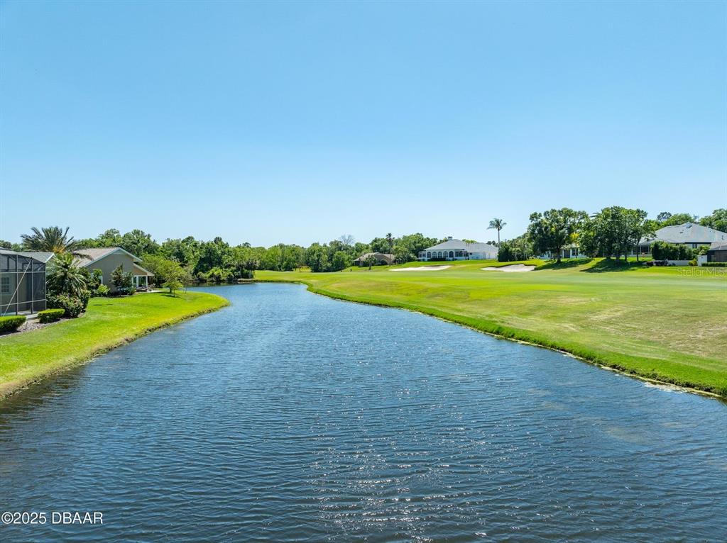 A kitchen features white cabinetry, stainless steel appliances, and light-colored countertops with tile flooring — 203 PRESTWICK DRIVE, NEW SMYRNA BEACH, FL
