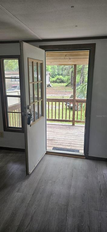An interior view shows a doorway opening onto a wooden deck with a railing — 3111 NE 167 PLACE, CITRA, FL