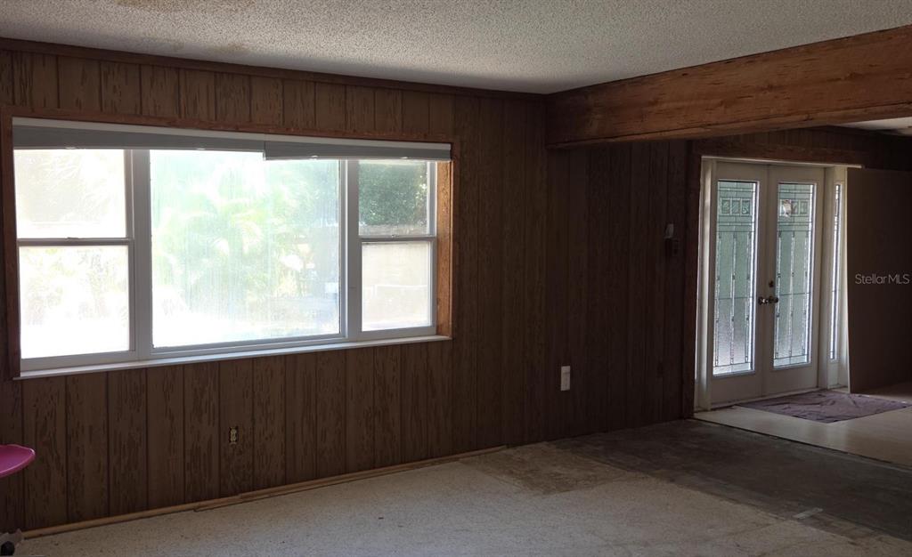 A stone fireplace with a wooden mantel and four small metal vents in a room — 8665 MOCKINGBIRD LANE, SEMINOLE, FL