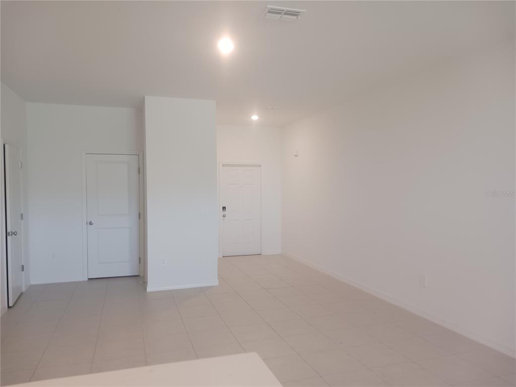 An interior view of a room with white walls, tiled floors, and two white doors — 8607 TROPICAL AIRE LANE, PARRISH, FL