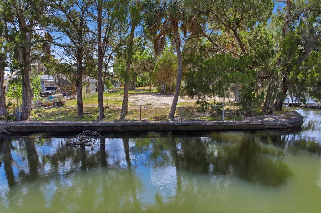 An aerial view of a waterfront lot featuring palm trees, a small shed, and a seawall — 1941 NW 16TH STREET, CRYSTAL RIVER, FL
