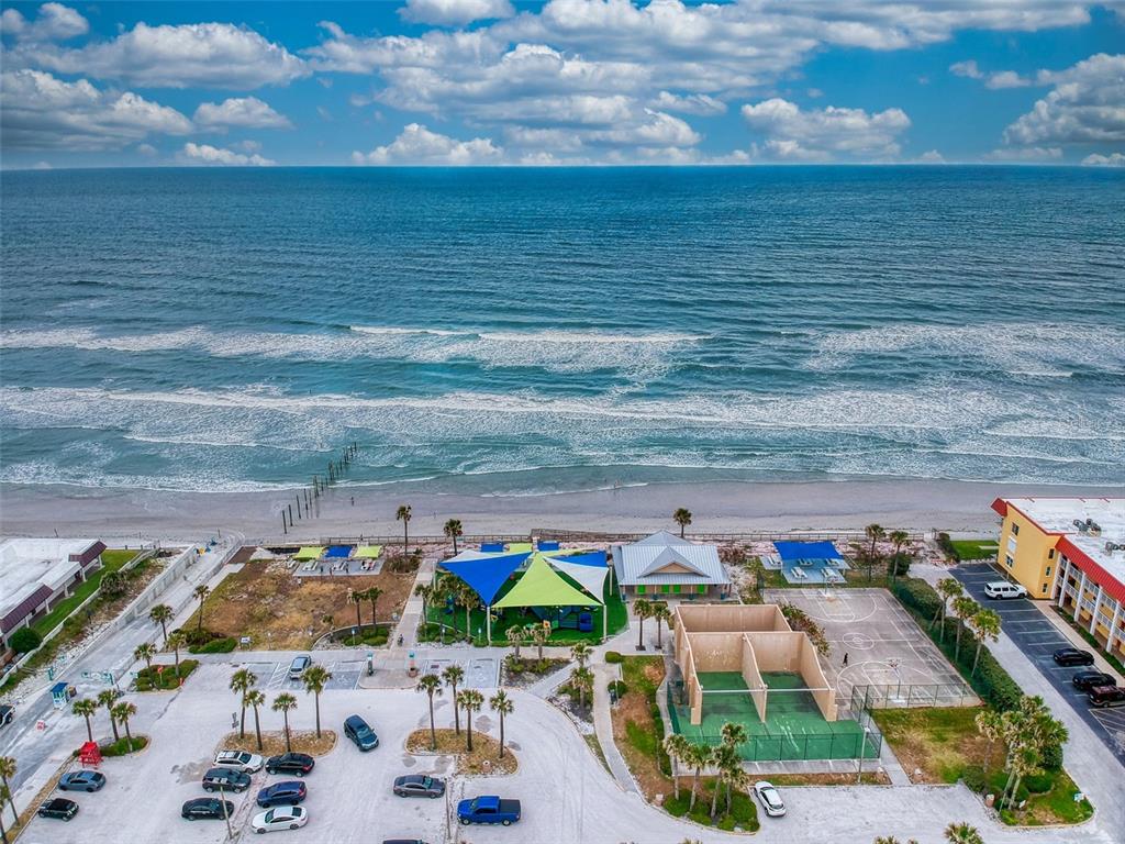 An aerial view of a blue multi-story apartment building with a central swimming pool — 3700 S ATLANTIC AVENUE UNIT 103, NEW SMYRNA BEACH, FL