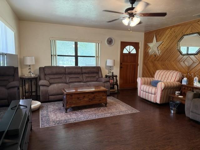 A living room features a brown sofa, a patterned rug, and wood-paneled walls — 14236 SW 76TH WAY, LAKE BUTLER, FL