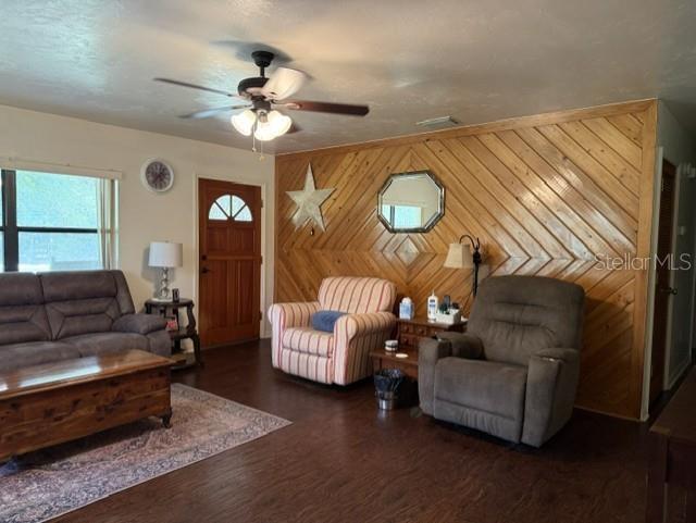 A living room features wood-paneled walls, a ceiling fan, a sofa, and two armchairs — 14236 SW 76TH WAY, LAKE BUTLER, FL