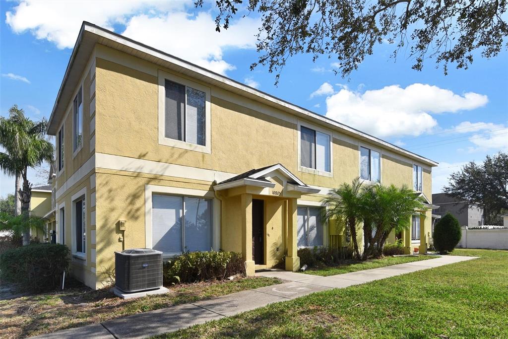 A two-story yellow stucco apartment building with a covered entryway and a concrete walkway — 10805 KEYS GATE DRIVE, RIVERVIEW, FL