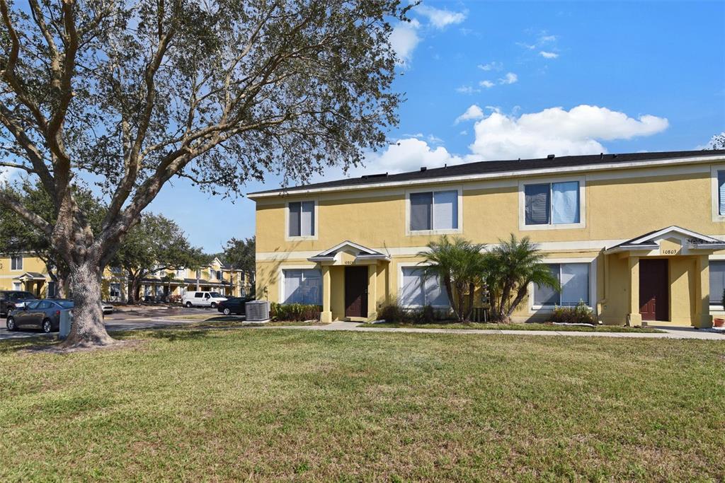 A two-story yellow apartment building with a grassy lawn and a large tree — 10805 KEYS GATE DRIVE, RIVERVIEW, FL