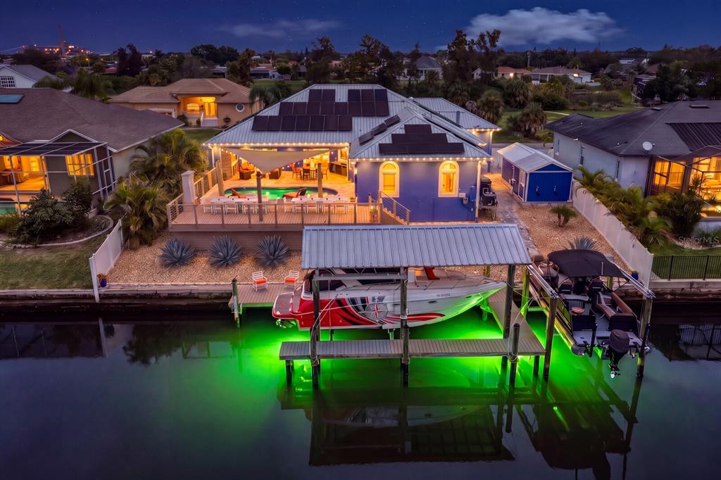 An aerial view of a waterfront house with a pool, solar panels, and a boat lift — 704 EAGLE LANE, APOLLO BEACH, FL