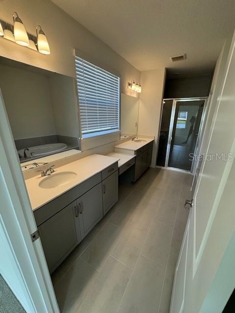 A bathroom features a double vanity with grey cabinets, a large mirror, and a shower — 144 CEDAR KNOLL CIRCLE, ST AUGUSTINE, FL