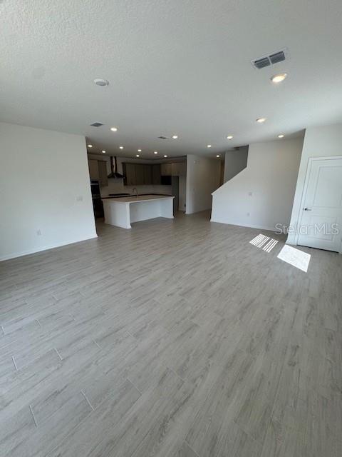An open-concept living area features light wood-look tile flooring and a kitchen with an island — 144 CEDAR KNOLL CIRCLE, ST AUGUSTINE, FL
