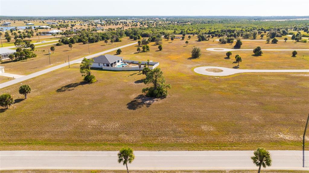 An aerial view shows a single-story house with a pool in a large, grassy lot — 99 HARNESS ROAD, PLACIDA, FL