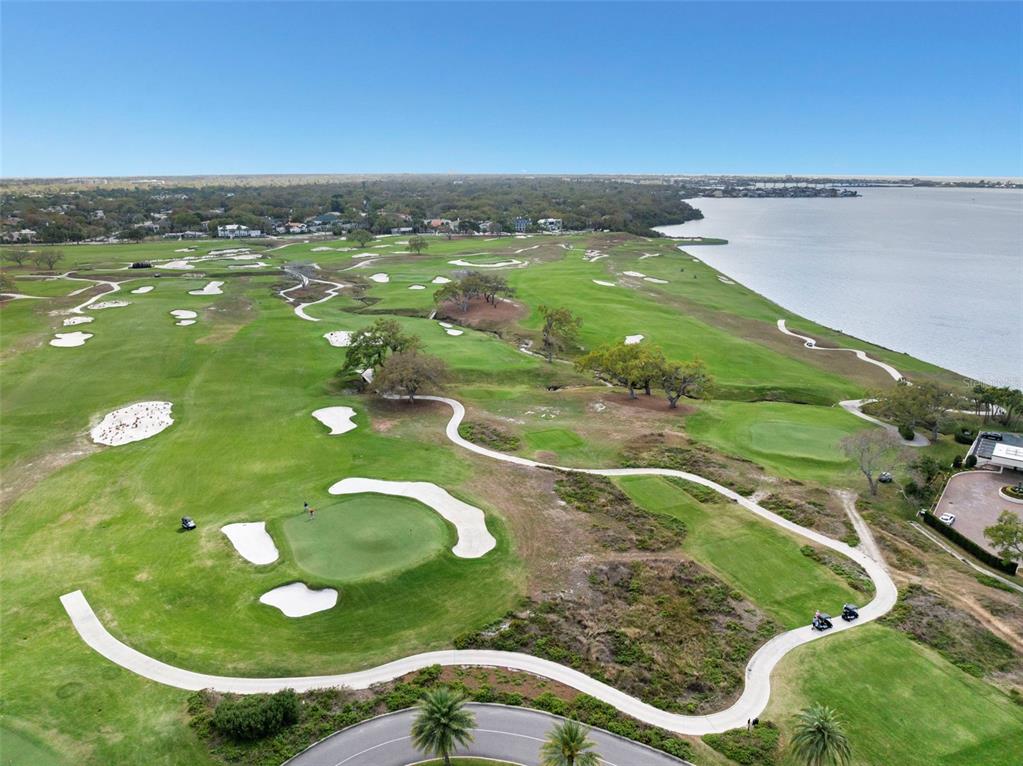 An aerial view of a golf course featuring sand bunkers, green fairways, and a large lake — 4 BELLEVIEW BOULEVARD UNIT 205, BELLEAIR, FL