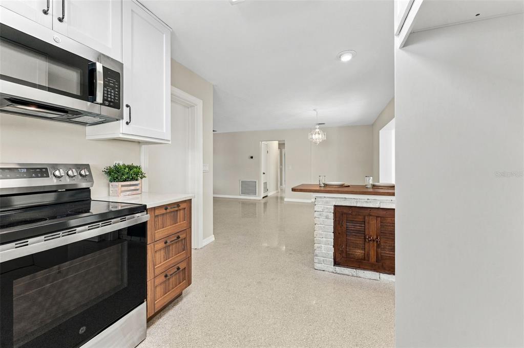 A kitchen with white cabinets, stainless steel appliances, and a brick-based breakfast bar — 2116 W MINNEHAHA STREET, TAMPA, FL