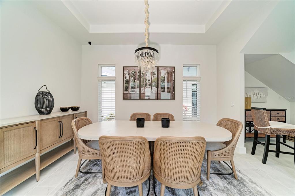 A two-story white house with palm trees, a paved walkway, and blue shutters — 5935 CAT CLAW LANE, BRADENTON, FL
