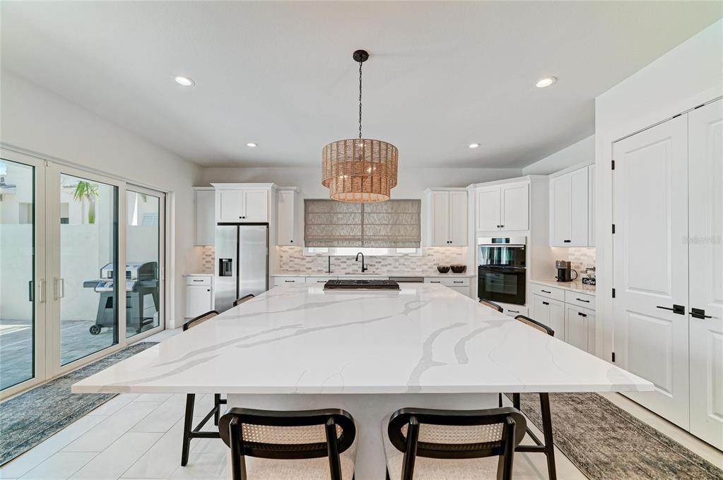 An aerial view of a modern white house with a gray tile roof and palm trees — 5935 CAT CLAW LANE, BRADENTON, FL