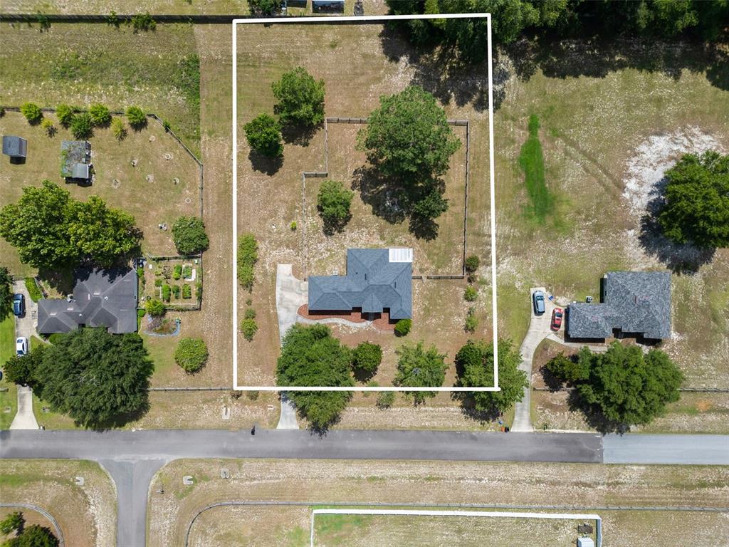 An aerial view shows a single-story house with a fenced backyard on a large lot — 9445 SW 96TH TERRACE, GAINESVILLE, FL