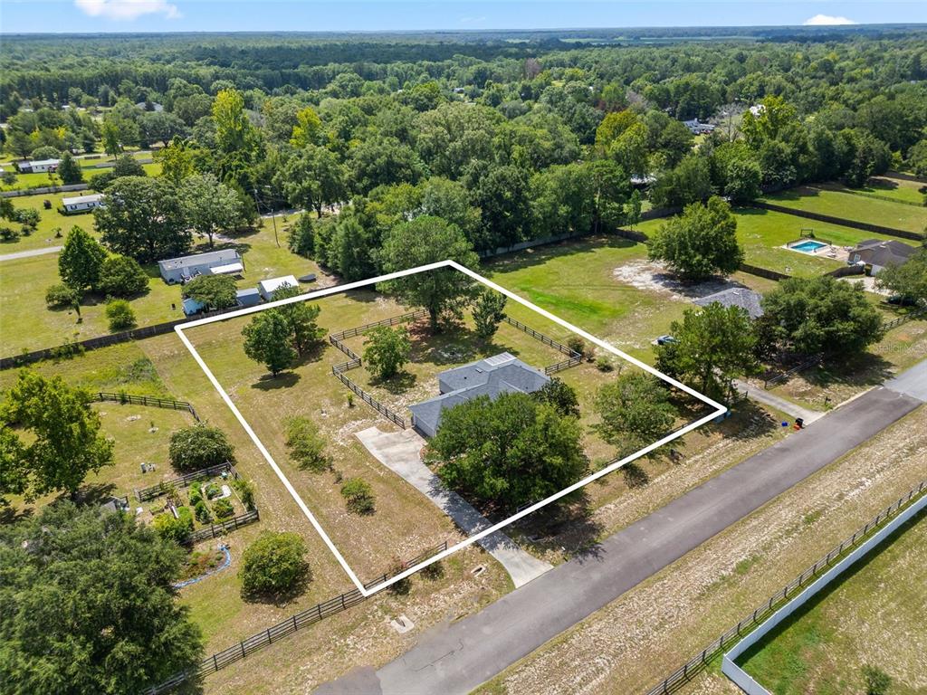 An aerial view shows a single-story house on a large, fenced lot with mature trees — 9445 SW 96TH TERRACE, GAINESVILLE, FL