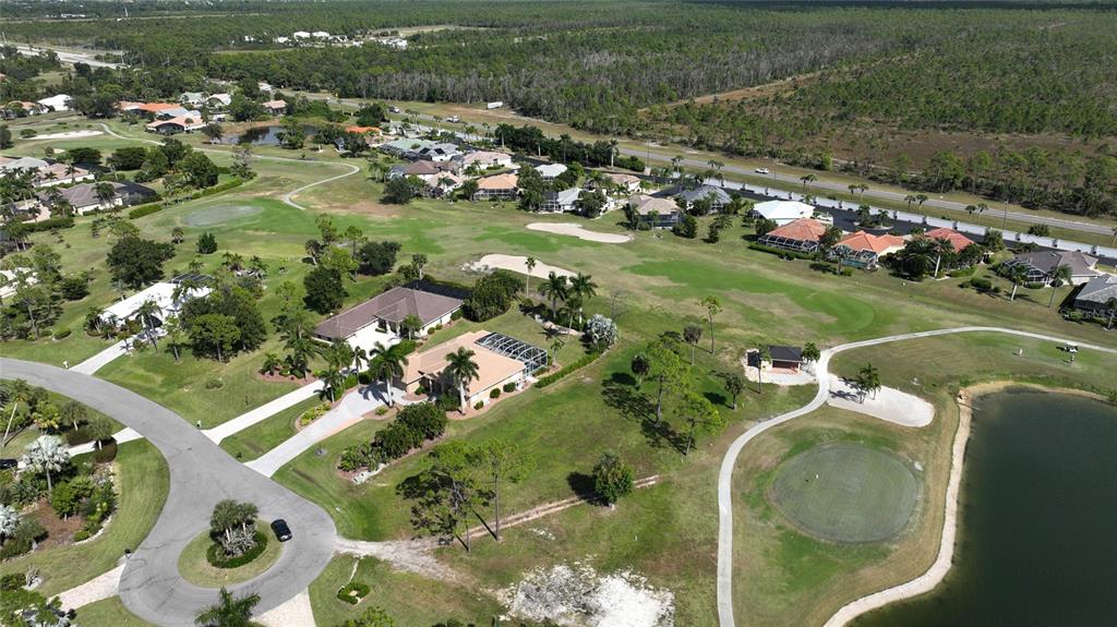 An aerial view shows houses situated along a golf course with a pond and road — 3000 BIG BEND CIRCLE, PUNTA GORDA, FL