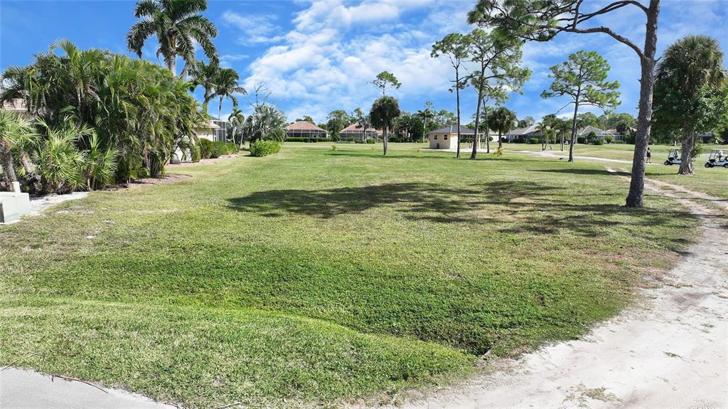 A grassy vacant lot with palm trees and golf course views under a blue sky — 3000 BIG BEND CIRCLE, PUNTA GORDA, FL