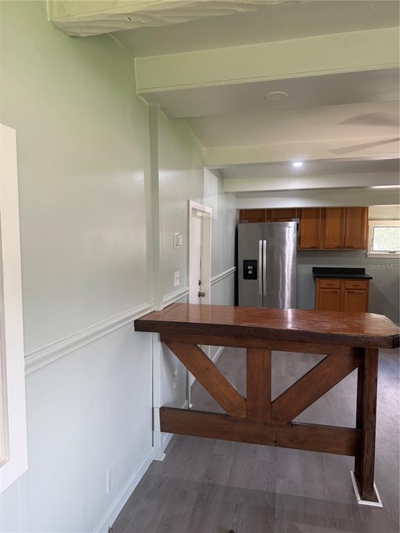 A kitchen features a wooden breakfast bar, light-colored walls, and gray wood-look flooring — 6967 POMPEI ROAD, ORLANDO, FL
