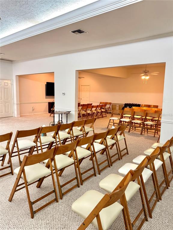 A large, carpeted room is set up with rows of wooden folding chairs for seating — 2605 BAYVIEW STREET, SEBRING, FL
