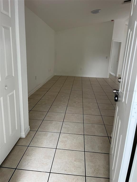 An empty room features light-colored square floor tiles and white walls — 3049 SE 38TH AVENUE, OKEECHOBEE, FL