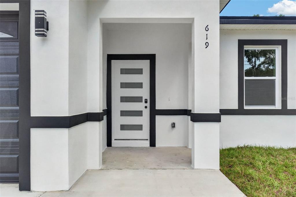 The exterior of a house features a white front door with five horizontal glass panels — 619 W VALENCIA STREET, LAKELAND, FL