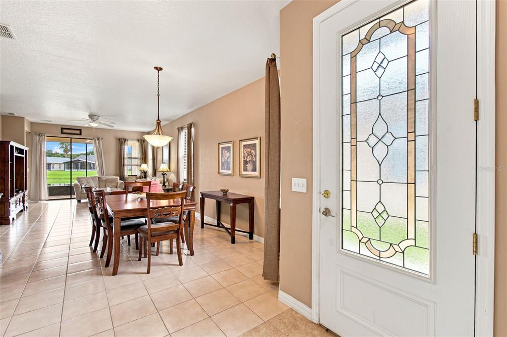 An entryway leads into a dining area with tile floors and a glass-paneled front door — 133 GRAND CANAL DRIVE, POINCIANA, FL