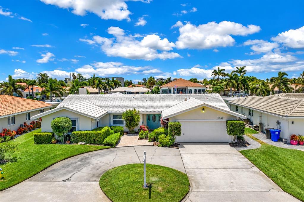 A single-story house with a white roof, light-colored siding, and a circular driveway — 2067 MASSACHUSETTS AVENUE NE, ST PETERSBURG, FL