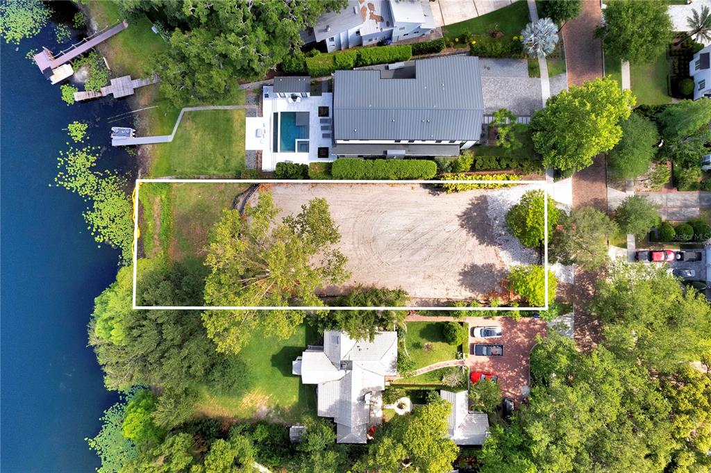 An aerial view shows a vacant, rectangular waterfront lot situated between two existing residential properties — 313L SYLVAN DRIVE, WINTER PARK, FL