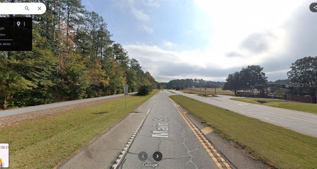 A view of a paved road with trees on the left and a grassy field — US-27, FROSTPROOF, FL