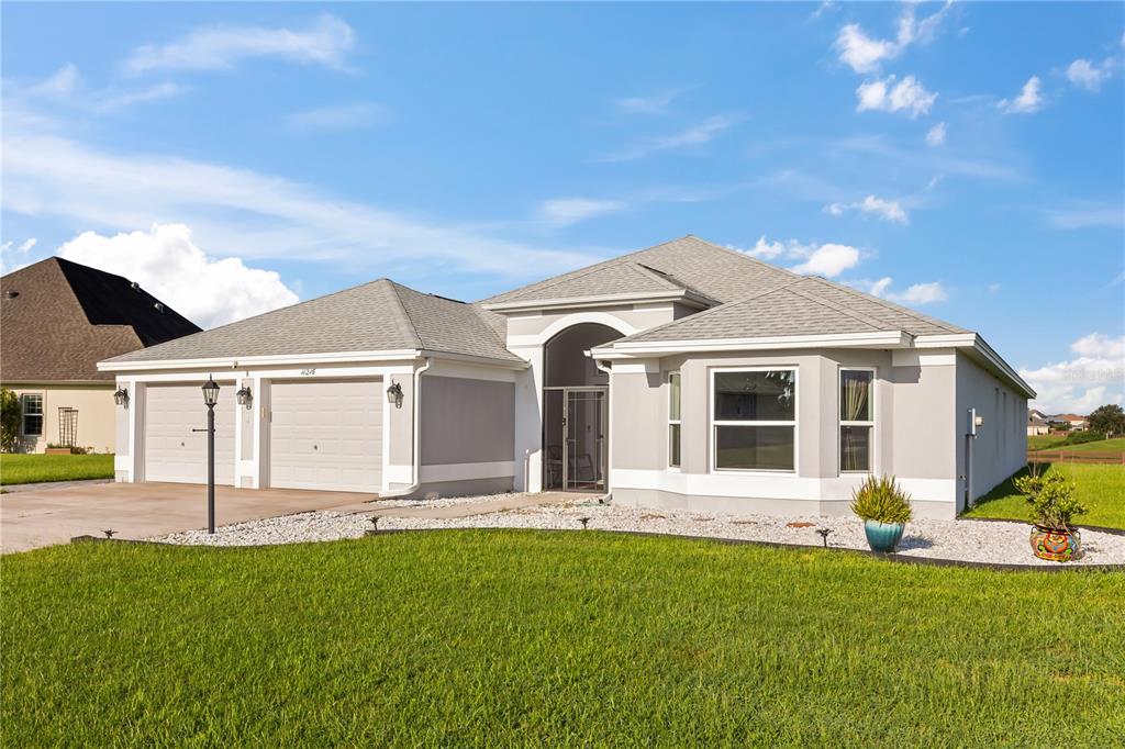 An aerial view shows a single-story house with a two-car garage and a concrete driveway — 11216 ROZ WAY, OXFORD, FL