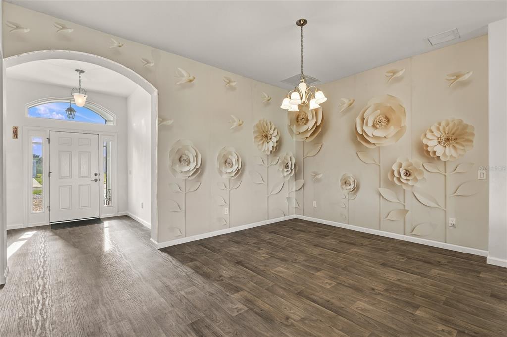 A kitchen features dark wood cabinets, a large granite-topped island, and three upholstered bar stools — 11216 ROZ WAY, OXFORD, FL