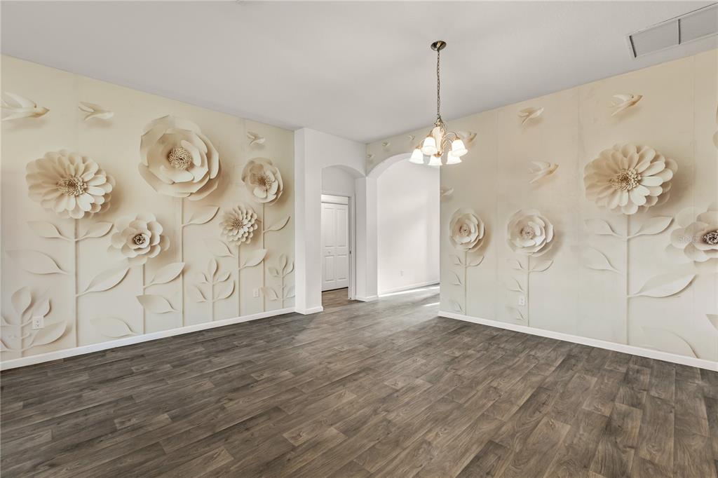 A kitchen features gray cabinetry, stainless steel appliances, a runner rug, and a wreath — 11216 ROZ WAY, OXFORD, FL