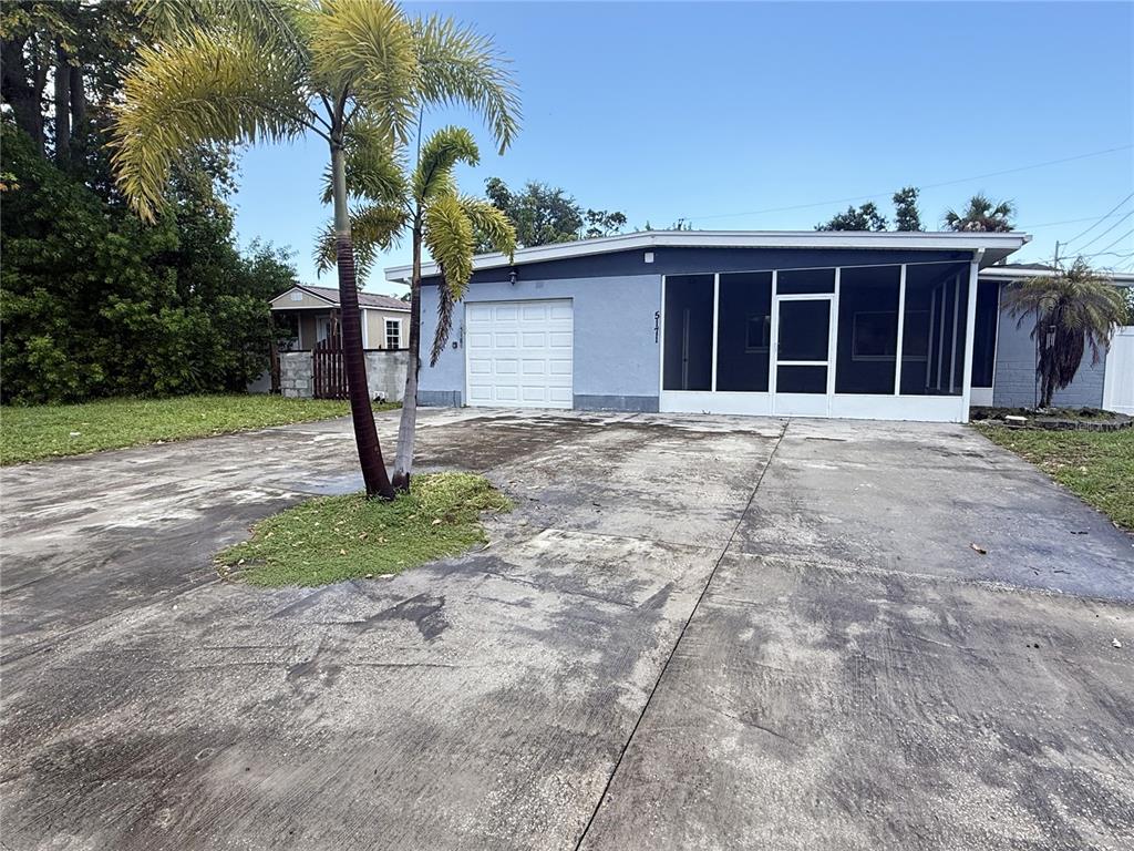 A single-story house with a blue exterior, a screened-in porch, and a concrete driveway — 5171 98TH AVENUE N, PINELLAS PARK, FL