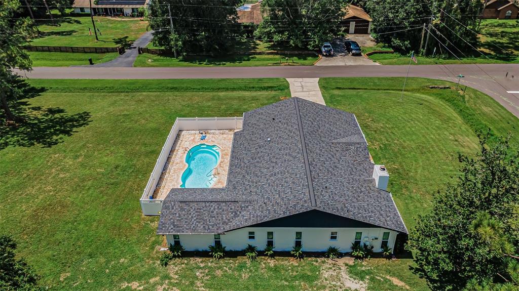 An aerial view of a house with a swimming pool enclosed by a white fence — 7812 WINDWARD WAY, ODESSA, FL