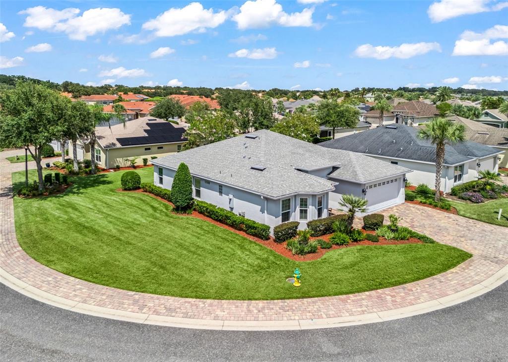 An aerial view of a single-story suburban house with a gray roof and paver driveway — 10038 KETCH KAY LANE, OXFORD, FL