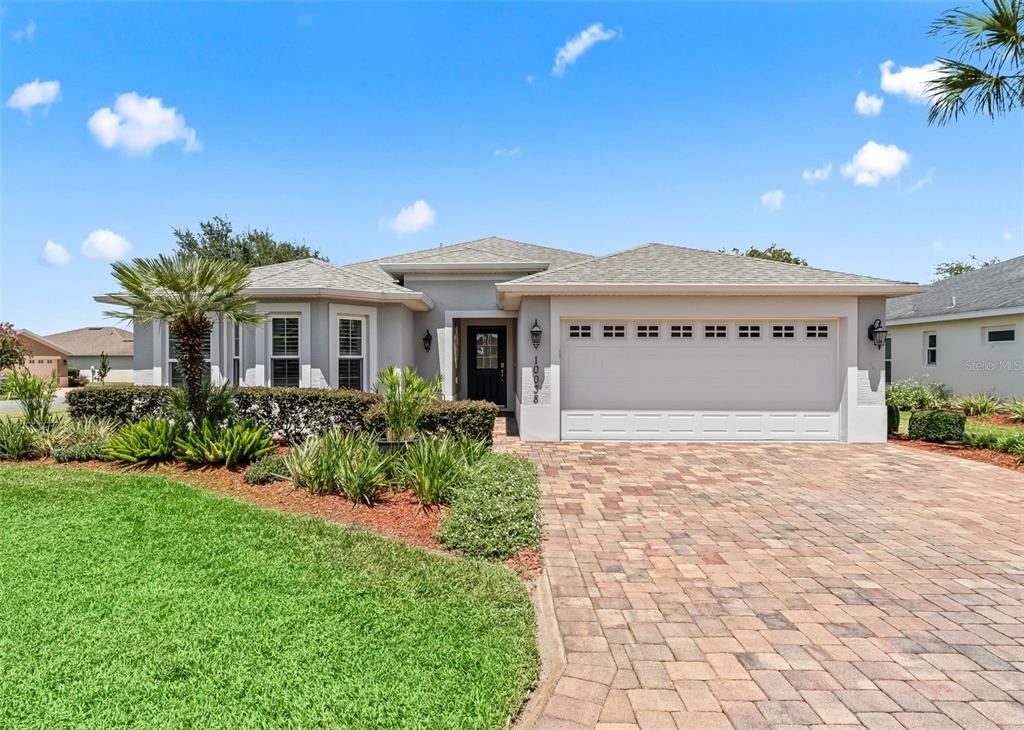 A single-story house with a paved driveway, a two-car garage, and a landscaped front yard — 10038 KETCH KAY LANE, OXFORD, FL