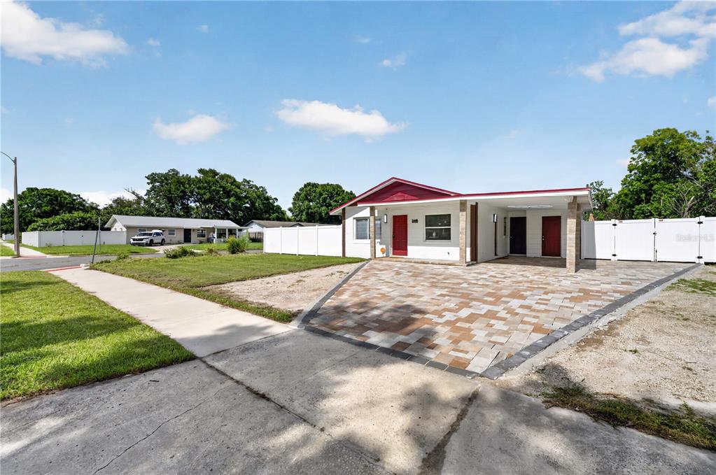 A single-story house with a red roof, white exterior, and a paved driveway — 1241 DEEROCK DRIVE, ORLANDO, FL