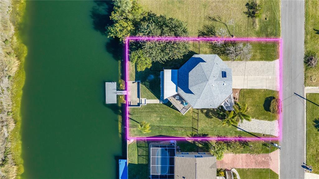 An aerial view shows a house with a dock on a canal and a driveway — 3460 CRAPE MYRTLE DRIVE, HERNANDO BEACH, FL