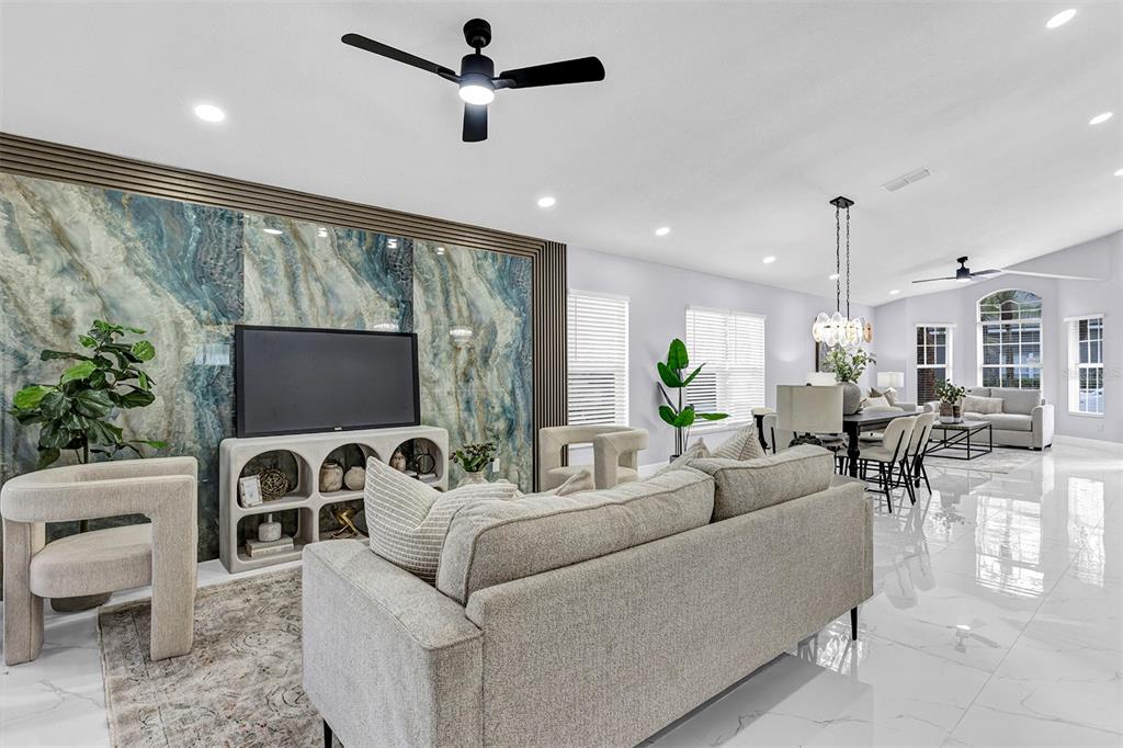 A living room features a blue marble accent wall, light furniture, and white tile floors — 13712 DEVLIN COURT, ORLANDO, FL