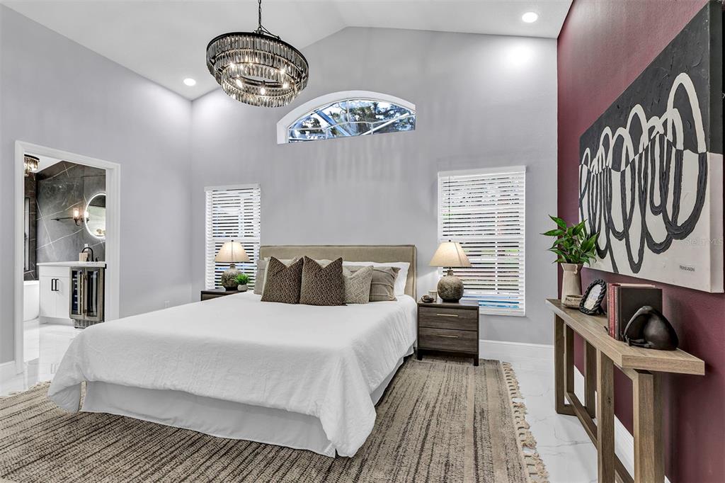 A bedroom features a vaulted ceiling, a crystal chandelier, and a large abstract wall painting — 13712 DEVLIN COURT, ORLANDO, FL