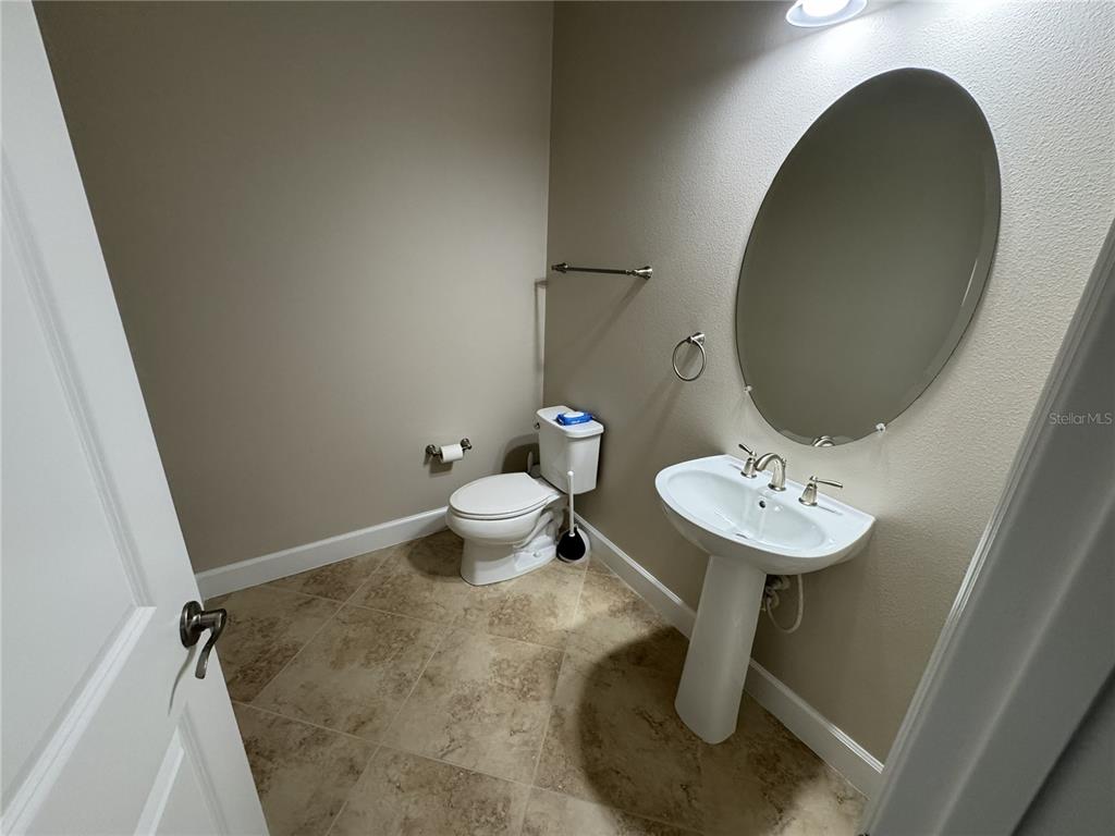 A half bathroom features a pedestal sink, an oval mirror, and a toilet on tile flooring — 5847 PALMER RANCH PARKWAY, SARASOTA, FL