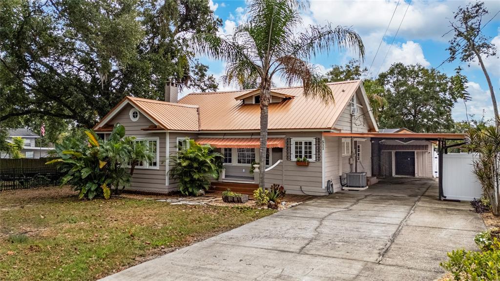 A single-story house with a metal roof, palm tree, and concrete driveway — 511 GLENDALE STREET, LAKELAND, FL