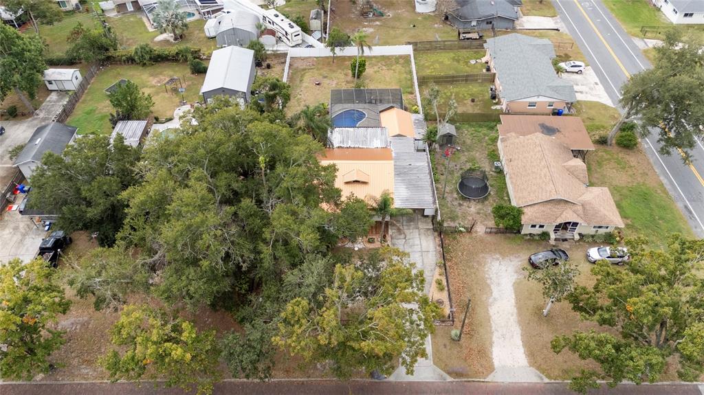 An aerial view shows a residential property with a pool, large trees, and a driveway — 511 GLENDALE STREET, LAKELAND, FL