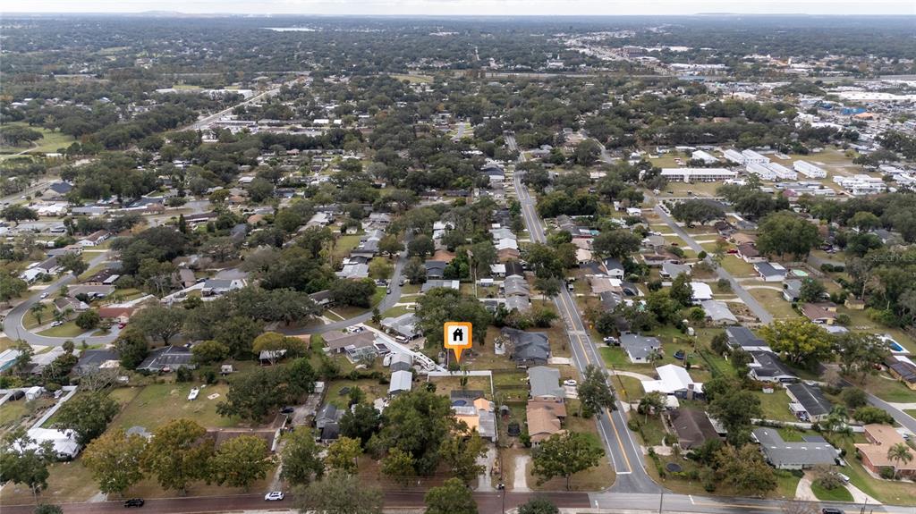 An aerial view shows a residential neighborhood with a highlighted house and surrounding trees — 511 GLENDALE STREET, LAKELAND, FL