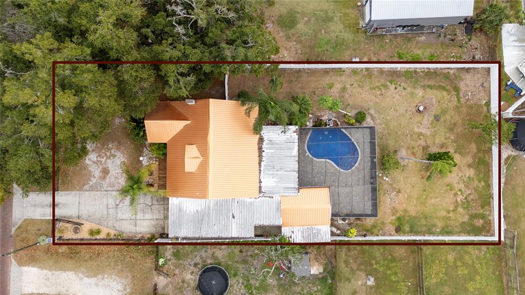 An aerial view shows a house with a metal roof, pool enclosure, and fenced yard — 511 GLENDALE STREET, LAKELAND, FL