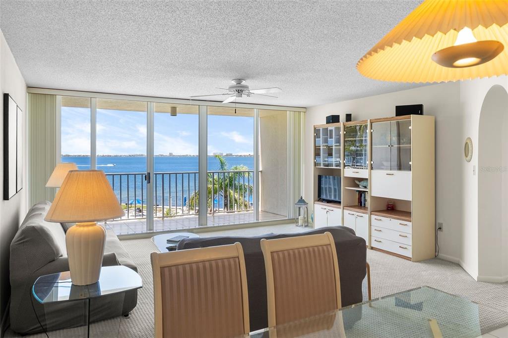 A living room with a sofa, dining chairs, and a balcony overlooking the ocean — 5155 ISLA KEY BOULEVARD S UNIT 304, ST PETERSBURG, FL