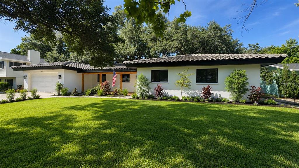 A single-story house with a white exterior, dark roof, and a manicured front lawn — 2218 HENNESEN DRIVE, CLEARWATER, FL