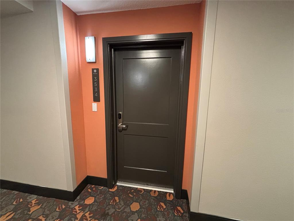 A dark brown apartment door with a unit number sign on an orange wall — 14501 GROVE RESORT AVENUE UNIT 3534, WINTER GARDEN, FL