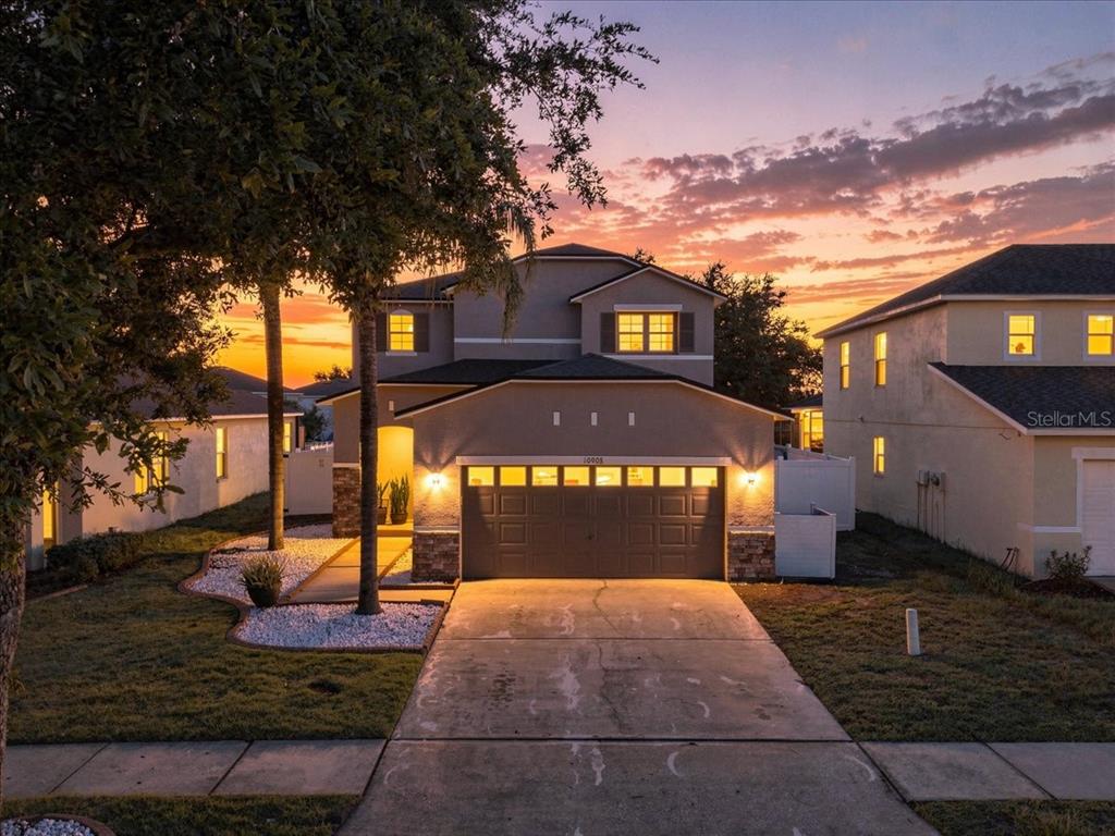 A two-story suburban house with a garage and driveway at sunset — 10908 SUBTLE TRAIL DRIVE, RIVERVIEW, FL